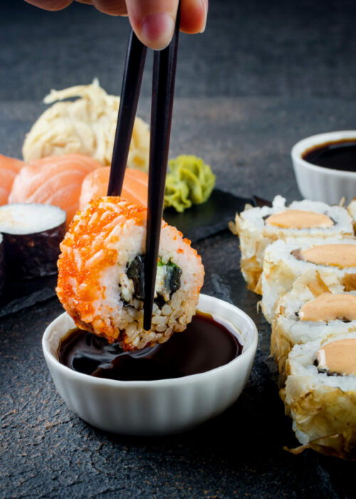 tasty-sushi-rolls-set-with-sauces-chopsticks-ginger-table